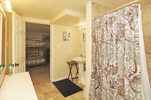 Bathroom with a textured ceiling and toilet