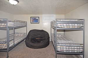 Carpeted bedroom featuring a textured ceiling