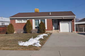 Ranch-style house with a front yard and a garage