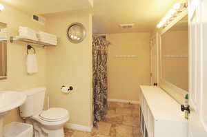 Bathroom featuring toilet, a textured ceiling, and walk in shower