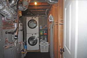 Washroom with stacked washer and clothes dryer and gas water heater