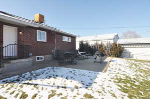 Snowy yard featuring a patio area