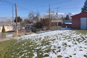 Snowy yard with a shed and a mountain view