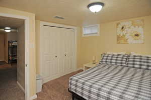 Bedroom featuring a textured ceiling, a closet, and carpet