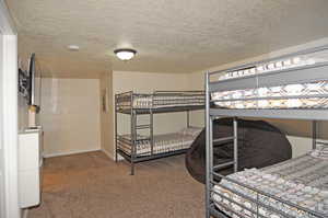 Carpeted bedroom with a textured ceiling