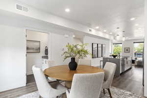 Dining room featuring dark wood-type flooring and a textured ceiling. This is the model home.