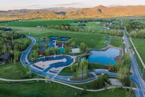 Aerial view at dusk featuring a water and mountain view and a rural view