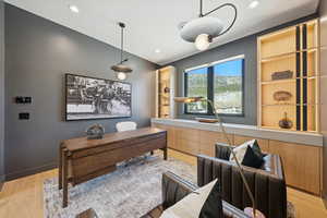 Home office featuring light wood-style floors, recessed lighting, and built in features