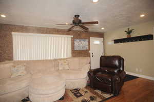 Living room featuring hardwood / wood-style flooring, a textured ceiling, and ceiling fan