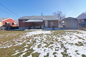 Snow covered property with a carport and a yard