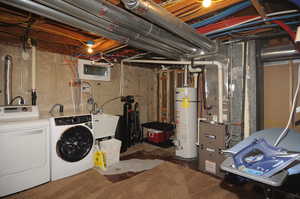 Basement featuring water heater, sink, and washing machine and clothes dryer