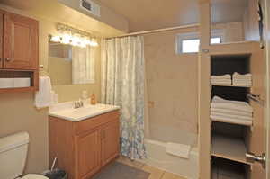 Full bathroom featuring toilet, vanity, tile patterned flooring, and shower / bathtub combination with curtain