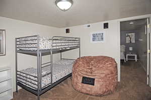 Bedroom featuring dark carpet