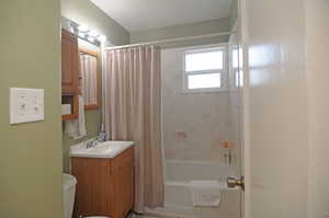 Full bathroom featuring toilet, shower / bath combo, and vanity