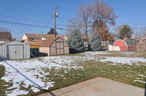 Snowy yard with a storage shed