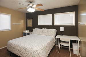 Bedroom featuring ceiling fan and dark colored carpet