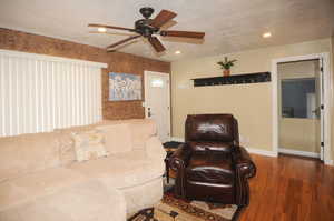 Living room featuring ceiling fan, a textured ceiling, and hardwood / wood-style floors