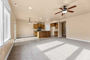 Unfurnished living room with ceiling fan and light colored carpet