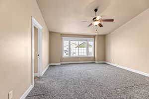 Empty room featuring ceiling fan and carpet