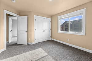 Unfurnished bedroom with a closet and carpet flooring