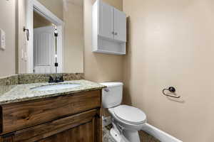 Bathroom with toilet, tile patterned floors, and vanity