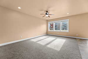 Carpeted spare room featuring ceiling fan