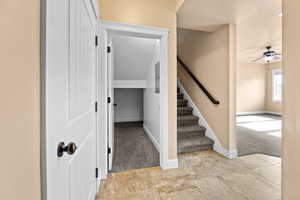 Stairway featuring ceiling fan and carpet flooring