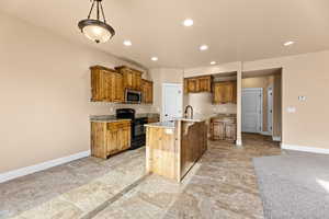 Kitchen with light stone countertops, pendant lighting, a kitchen island with sink, electric range, and a breakfast bar area