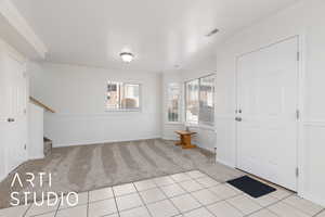 Carpeted foyer with ornamental molding