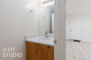 Bathroom featuring vanity, tile patterned flooring, and ornamental molding