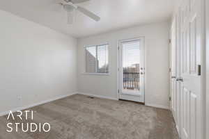 Carpeted empty room featuring ceiling fan