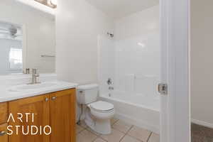 Full bathroom with tile patterned flooring, washtub / shower combination, vanity, toilet, and ceiling fan