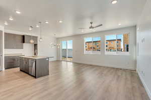 Kitchen featuring ceiling fan with notable chandelier, dark brown cabinetry, sink, a kitchen island with sink, and stainless steel dishwasher