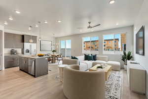 Living room featuring sink, ceiling fan with notable chandelier, and light hardwood / wood-style floors