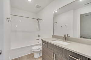 Full bathroom featuring toilet, shower / bathtub combination, wood-type flooring, and vanity