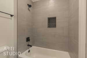 Bathroom with toilet and tiled shower / bath combo