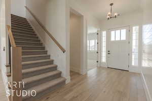 Entryway with light hardwood / wood-style flooring and an inviting chandelier