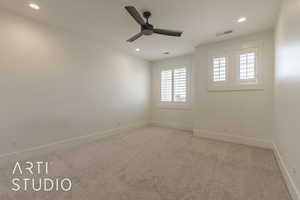 Carpeted spare room featuring ceiling fan