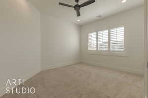 Empty room with ceiling fan and light colored carpet