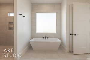 Bathroom with tile patterned floors, a bathtub, and plenty of natural light