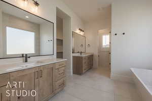 Bathroom featuring vanity, tile patterned floors, and a tub