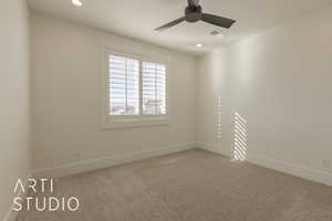 Empty room featuring ceiling fan and carpet floors