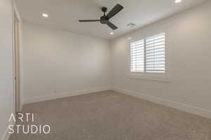 Carpeted spare room with ceiling fan