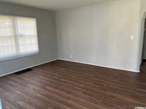 Unfurnished room featuring dark hardwood / wood-style floors