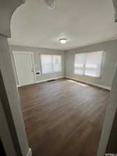 Unfurnished living room with dark hardwood / wood-style floors