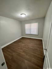 Empty room featuring dark hardwood / wood-style flooring