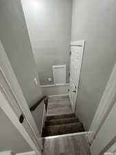 Stairway featuring hardwood / wood-style flooring