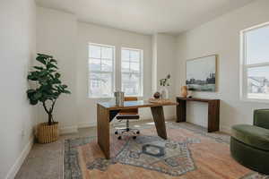 Office with light colored carpet and baseboards