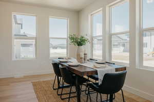 Dining room featuring light wood-type flooring, baseboards, and a wealth of natural light