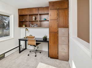 Office area with light colored carpet and a baseboard radiator